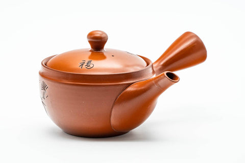 Elevated view showing the engraved decoration and the domed lid of the red clay teapot.