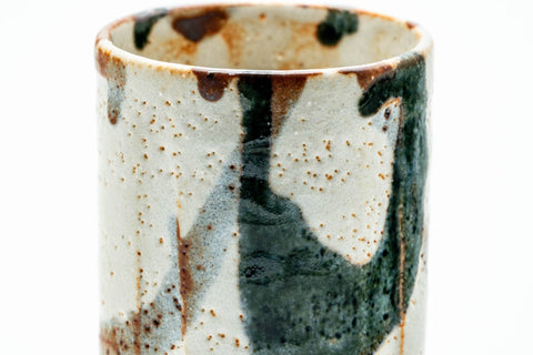 Overhead view into the cup, white Shino glaze with brush accents.