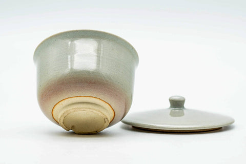 The lid lying flat beside the cup, showing the underside of the lid.
