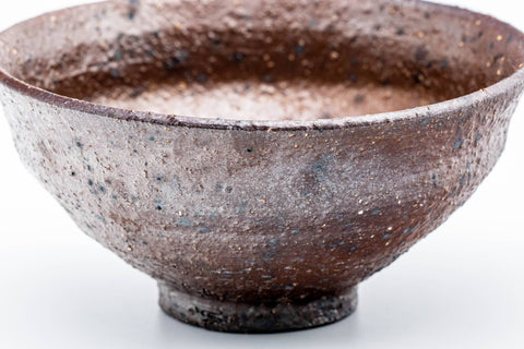 Full front view of the conical brown matcha bowl with its flaring tenmoku silhouette.
