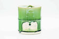 Front view of the bamboo-shaped jar emphasising the segmented form and green drip glaze.