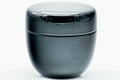 Close front view of the glossy black lacquer natsume caddy with the lid on.