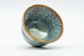 Teacup tilted to show the streaked glazed interior.