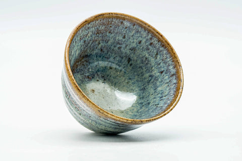 Teacup tilted to show the streaked glazed interior.