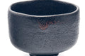 Three-quarter view of the black bowl with reddish flecks.