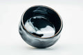 Overhead view looking into the glossy black interior of the chawan