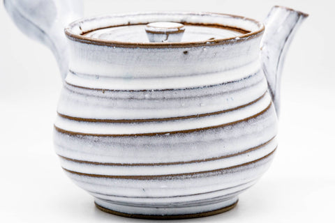 Close-up of the spiraling ribbed bands in the milky-white glaze with brown-toned edges.