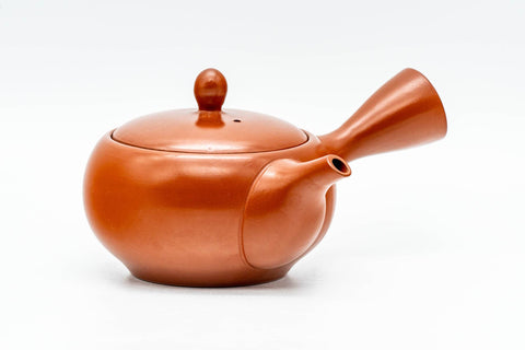 Front view of the burnt-orange teapot with domed lid and side handle.