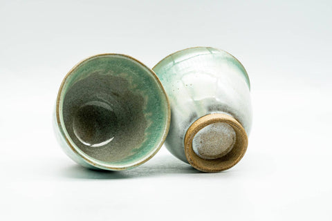 One cup lying on its side showing the glazed interior, the other upright showing its unglazed foot