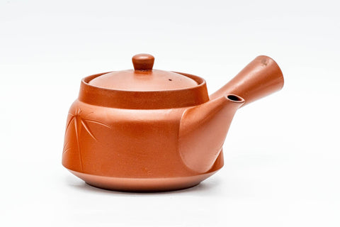 Red shudei Tokoname kyusu teapot, front view with lid on, showing the engraved bamboo motif and side handle