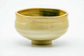 Cream-beige Akahada chawan, front view showing the green drip glaze