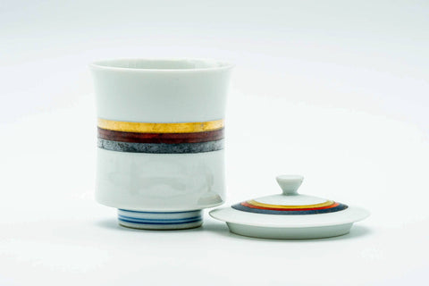 The cup upright with its lid lying flat beside it, showing the top of the lid.