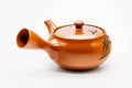 Side view of the red kyusu with the handle to the left, lid on.