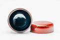The red caddy open and upright, looking into the dark glossy interior, with the red lid lying flat beside it.