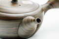 Overhead view of the dark green Tokoname kyusu showing the spiralling nerikomi swirl pattern across the body and lid