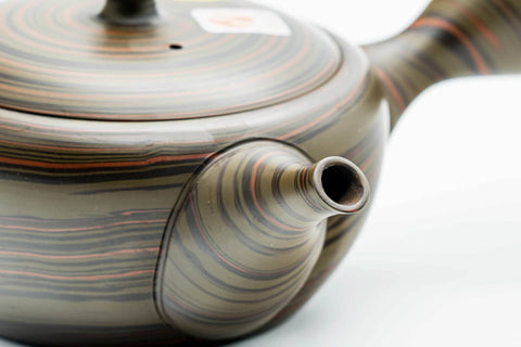 Overhead view of the dark green Tokoname kyusu showing the spiralling nerikomi swirl pattern across the body and lid