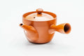 Rear three-quarter view of the red kyusu showing the side handle.