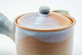 Closeup of the pink-beige Hagi-yaki kyusu with lid on, showing the pale drip glaze