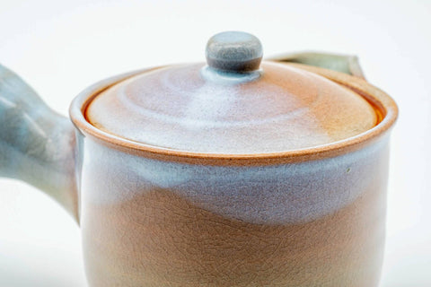 Closeup of the pink-beige Hagi-yaki kyusu with lid on, showing the pale drip glaze