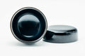 Glossy black-urushi matcha tea caddy, lid off, body upright with lid lying beside, three-quarter view of the black interior