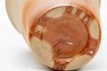 Angled close-up showing the unglazed clay bases and feet of the two cups.