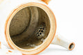 Teapot with the lid removed, angled to reveal the interior and built-in ceramic strainer.