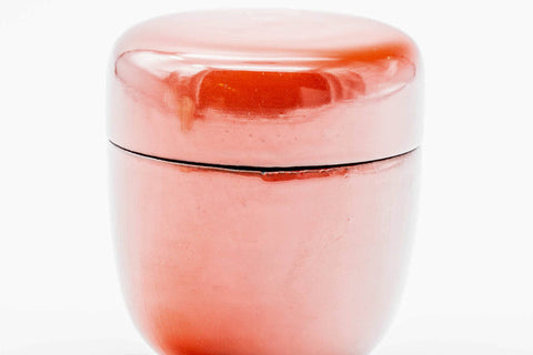 Close-up of the closed red lacquer caddy showing the mottled glossy red tones.