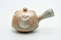 Beige-pink weathered Hagi-yaki kyusu, raised three-quarter view showing the lid knob