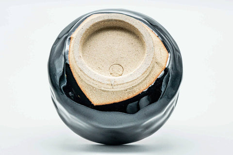 Inverted view of the black chawan showing the carved foot and exposed clay underside
