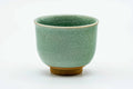 Side view of the celadon teacup, showing the crackled turquoise glaze.