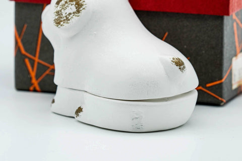 The lid separated from the base, showing the puppy-form lid and the base, beside the box.