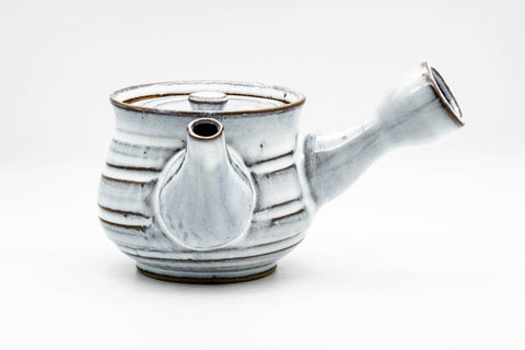 Front view of the white teapot with the spout facing forward and a small knobbed lid.