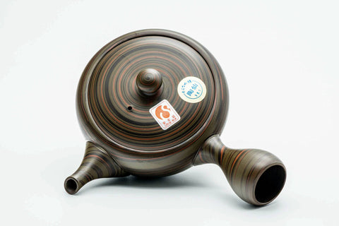 Dark green nerikomi Tokoname kyusu, side profile with a small sticker on the body for scale and the spout to the right