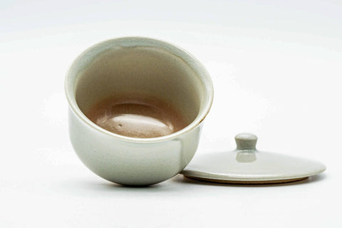 The cup with the lid set beside it, revealing the interior and rim.