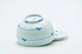 The teacup tipped to show the foot, with the lid set beside it.