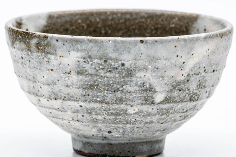 Front view of the chawan highlighting the milky drip glaze and texture.