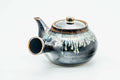 Side view of the kyusu with the handle to the left, lid on, showing the spout.