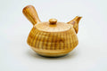 Yellow-brown glazed Arita-yaki side-handle kyusu with banded striping, lid on, three-quarter view.