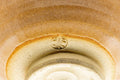 Close-up of the foot and base showing the unglazed clay and maker's mark.
