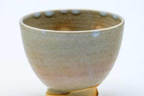 Close-up three-quarter view of one cup, showing the pale glaze with subtle tonal variation.