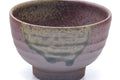 Close-up showing the green ash-glaze drips over the purple-brown body.