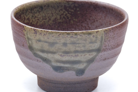 Close-up showing the green ash-glaze drips over the purple-brown body.