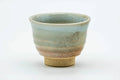 Side view of the teacup, showing the mottled weathered glaze.