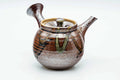 Side view of the drip-glazed kyusu with the handle to the right, lid on.