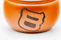 Closeup of the glossy red shudei body of the Tokoname kyusu with an engraved character motif
