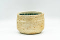 Front view tilted slightly forward to reveal the mottled blue-green interior glaze inside the cup.