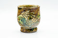 Yunomi with engraved fish motif and iridescent gold-green lustre glaze, front view.