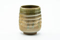 Beige-green drip-glazed yunomi with a spiraling throwing texture, front view.