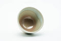 Interior view of a teacup revealing the pale glazed inside and rim.