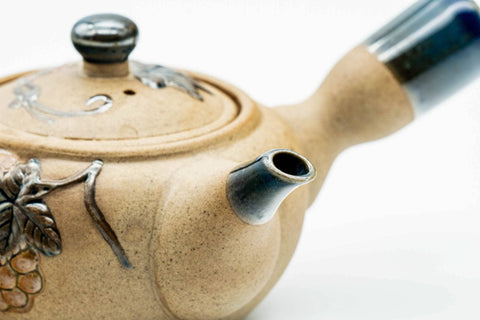 Side view showing the spout and grapevine painting, lid on.